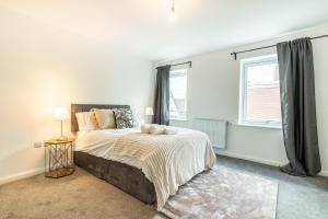 a bedroom with a large bed and a window at Comfy 2-Bed Flat in Dartford, Kent. in Kent