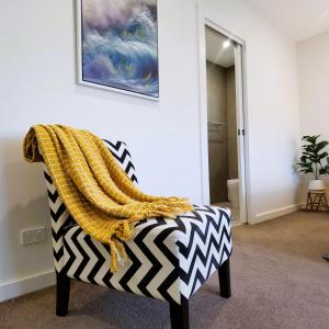 a couch with a yellow and black blanket on it at Altona entire 3 bedrooms house in Altona