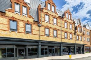 a large brick building with windows on a street at Comfy 2-Bed Flat in Dartford, Kent. in Kent