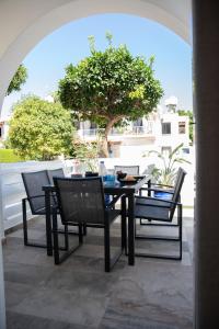 a table and chairs on a patio with a tree at Taheli Riverside Townhouse in Tourist Area in Paphos City