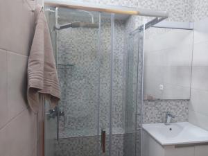 ein Badezimmer mit einer Glasdusche mit Waschbecken in der Unterkunft Angela Beach Place in Vila Baleira + 13 Fotos