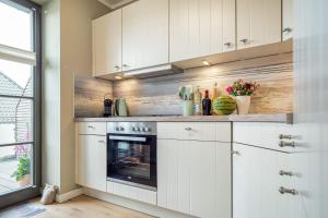 a kitchen with white cabinets and an oven at 54 Grad Nordost in Zingst