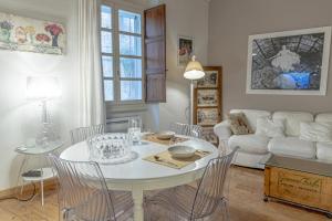 ein Wohnzimmer mit einem Tisch, Stühlen und einem Sofa in der Unterkunft La Cona boutique apartment in centro in Sassari