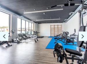 a gym with several treadmills and machines in a room at Dune Apartment in Kołobrzeg