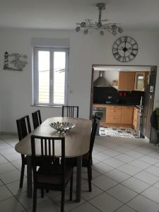 cocina y comedor con mesa y sillas en Location petit fort philippe maison 3 chambres 6 personnes en Gravelines