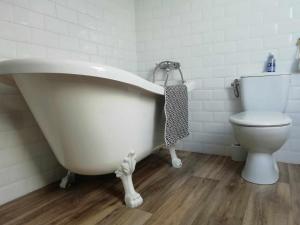 een badkamer met een wit bad en een toilet bij Studio au coeur de la vallée de la Loire in Azay-sur-Cher