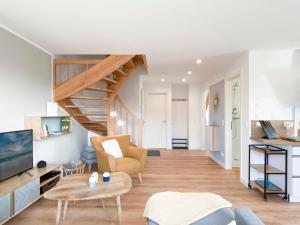 a living room with a staircase and a couch at Beach Loft in Zingst