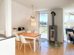 a kitchen and dining room with a table and a fireplace at Bi de Wisch, OG in Prerow