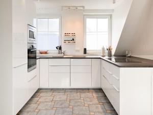 a white kitchen with white cabinets and appliances at Bi de Wisch, OG in Prerow