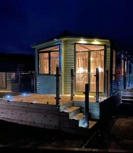 una casetta minuscola con terrazza in legno di notte di 2-Bed Lodge in Cockermouth a Cockermouth