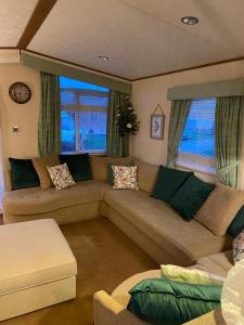 un soggiorno con divano e 2 finestre di 2-Bed Lodge in Cockermouth a Cockermouth