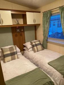 2 letti posti in una stanza con finestra di 2-Bed Lodge in Cockermouth a Cockermouth