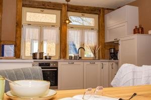 une cuisine avec des placards blancs et une table en bois dans l'établissement Cozy Four, à Zingst