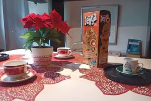 una mesa con dos tazas y un jarrón con flores rojas en Loft-Departamento encantador con estacionamiento, en San Andrés Tuxtla