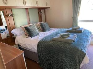 a bedroom with a bed with two towels on it at Lodge - Sleeps 6 - Parking - Garden in Cockermouth