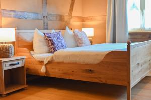 - une chambre avec un lit en bois et des oreillers dans l'établissement Cozy Four, à Zingst