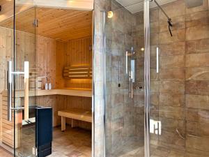 La salle de bains est pourvue d'une douche avec une porte en verre. dans l'établissement Cozy Four, à Zingst