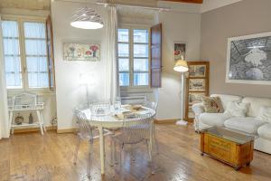 ein Wohnzimmer mit einem Tisch und einem Sofa in der Unterkunft La Cona boutique apartment in centro in Sassari