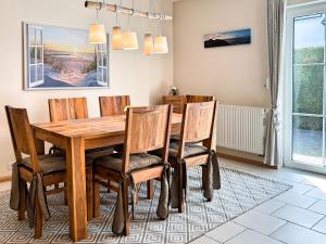 a dining room with a wooden table and chairs at Darßwaldradler in Wieck