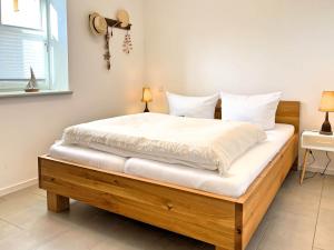 sypialnia z dużym łóżkiem z białą pościelą w obiekcie Cozy Two w Zingst