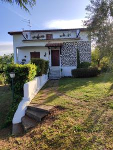 uma casa branca com uma porta e um quintal em Casale Bambù - Hidden Countryhouse em Rocca Massima