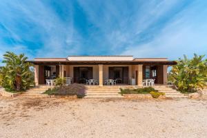 a house on the beach with chairs and trees at Villa con piscina 429 in Torre Pali 