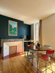 Habitación con mesa, sillas y chimenea. en Le Canadair, Grand T2 lumineux, en Montauban