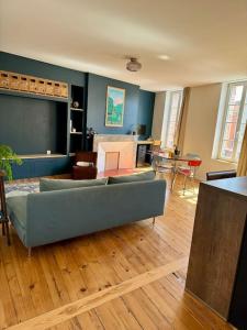 sala de estar con sofá azul y suelo de madera en Le Canadair, Grand T2 lumineux, en Montauban