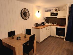 a kitchen with a wooden table and a dining room at Appartement 4-6 pers proche centre village in Saint-Lary-Soulan