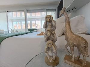a statue of a monkey and a giraffe on a bed at Spacious Studio by the University in San Vicente del Raspeig