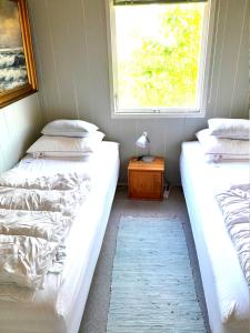 two beds in a small room with a window at The Beach House in Haderslev