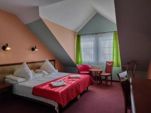 カルパチにあるDW Mieszkoのベッドルーム1室(赤毛布とテーブル付きのベッド1台付)