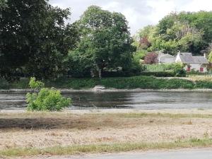 een rivier met een huis op de achtergrond bij Studio au coeur de la vallée de la Loire in Azay-sur-Cher