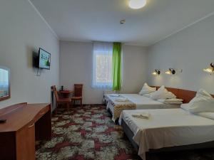 Cette chambre comprend deux lits et un bureau. dans l'établissement DW Mieszko, à Karpacz