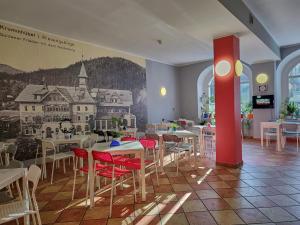 卡爾帕奇的住宿－DW米喜客酒店，一间设有桌椅的餐厅,墙上挂着壁画