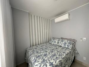 um pequeno quarto com uma cama com um edredão em Lindo Apartamento em Brasília