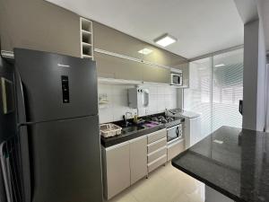 uma cozinha com um frigorífico de aço inoxidável e um lavatório em Lindo Apartamento em Brasília