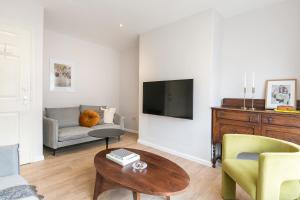 een woonkamer met een bank en een tv bij Spacious 4 bedroom home - sleeps 8 in Manchester
