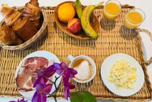 - une table en rotin avec un petit-déjeuner composé de pain et de fruits dans l'établissement Sun Beach, à Ajaccio