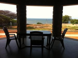 a table and chairs in a room with a window at Joppa House in Kanyakumari
