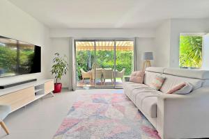 un salon avec un canapé et une télévision dans l'établissement The Flower Garden, à Nice