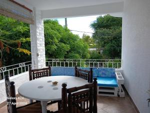 a table and chairs on a balcony with a table and a couch at The Coral House in Rivière Noire