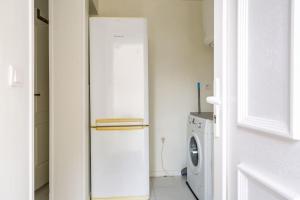 einen weißen Kühlschrank in einer Küche mit Waschmaschine in der Unterkunft studio lumineux in Choisy-le-Roi