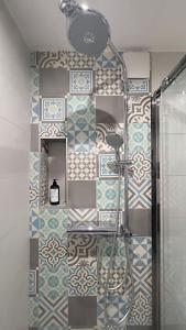 La salle de bains est pourvue d'une douche et d'un mur carrelé. dans l'établissement The Flower Garden, à Nice