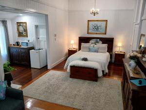 a bedroom with a bed and a table and a couch at Memory Lane Accommodation in Mount Tamborine