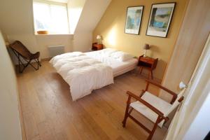 a bedroom with a bed and a chair and a window at 534-Villa de la plage-Plage a 100m in Audierne