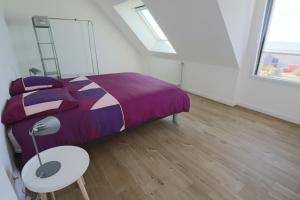 una camera da letto con un letto, un tavolo e finestre di 695-Villa Kersiny proche plages a Plouhinec