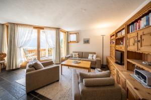 a living room with two couches and a tv at Chasa Munt Plan in Scuol