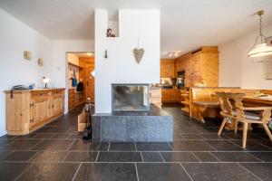 a kitchen with a fireplace and a table and chairs at Chasa Munt Plan in Scuol