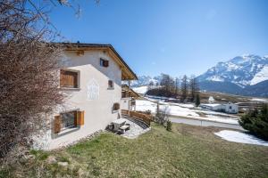 a house on a hill with mountains in the background at Chasa Munt Plan in Scuol